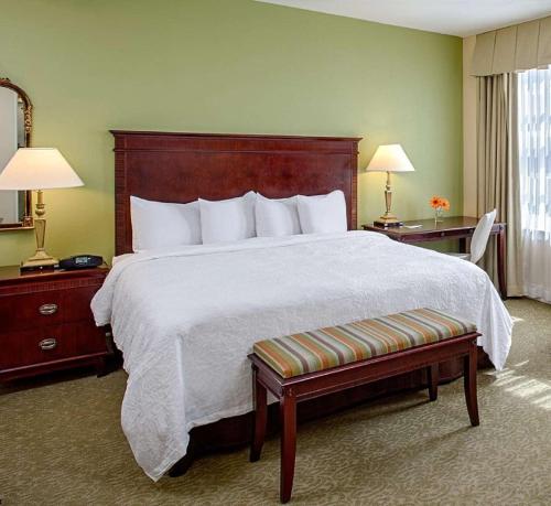 伯明翰伯明翰市中心塔特怀勒汉普顿套房酒店 的一间卧室配有一张大床和木制床头板