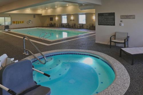 比林斯比林斯汉普顿酒店的酒店带游泳池的客房内设有一个按摩浴缸。