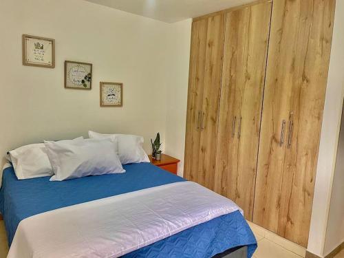 拉特瓦伊达Atardecer Quindiano的一间卧室配有一张床和一个大型木制橱柜