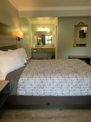 蒙特雷蒙特利海滨旅馆的一间卧室配有一张大床和镜子