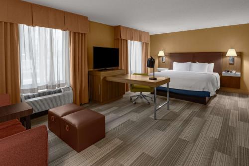 班宁汉普顿酒店 - 班宁/博蒙特的配有一张床和一张书桌的酒店客房