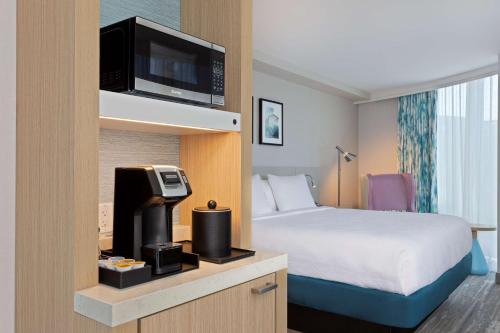 布鲁克林Hilton Garden Inn Boston Brookline, Ma的一间酒店客房,配有一张床和一台电视