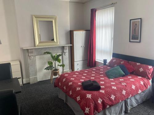 贝尔法斯特bnb的一间卧室配有一张带红色毯子和镜子的床