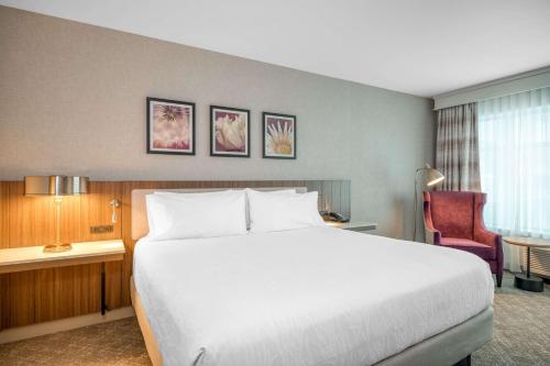 波士顿波士顿洛根机场希尔顿花园酒店的酒店客房带一张大床和一把椅子