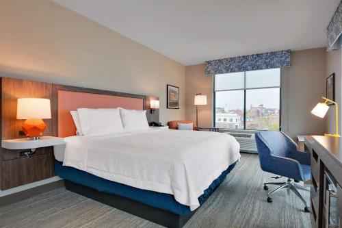 塞伦Hampton Inn Salem, Ma的配有一张床、一张书桌和一扇窗户的酒店客房