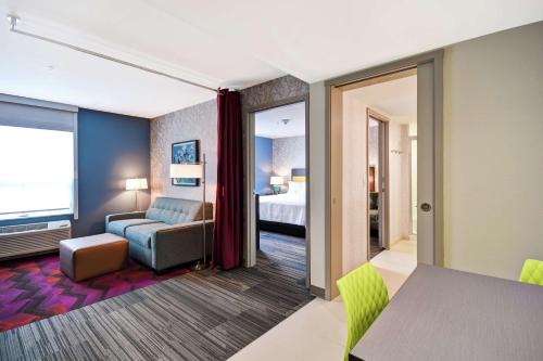 福克斯伯勒Home2 Suites By Hilton Walpole Foxborough的酒店客房配有床、沙发和桌子。