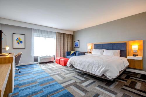 沃尔瑟姆波士顿/沃尔瑟姆汉普顿酒店及套房的酒店客房设有一张大床和一张沙发。