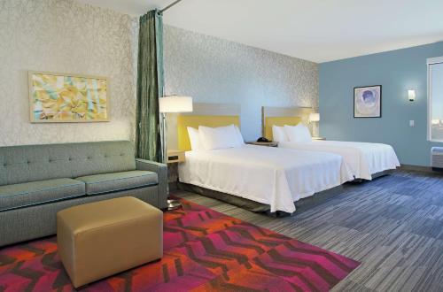 亚瑟港Home2 Suites By Hilton Port Arthur的酒店客房,设有两张床和一张沙发