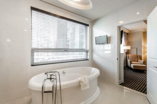 蒙特利尔圣马丁别墅酒店的白色的浴室设有浴缸和窗户。