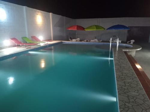 HuanchaquitoLa casa de Maria- Playa Huanchaquito的一个带椅子和遮阳伞的游泳池