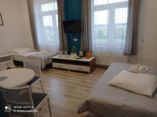 MąkoszynCentrum Wypoczynkowe COMPLEX的酒店客房带两张床和一张桌子以及椅子。