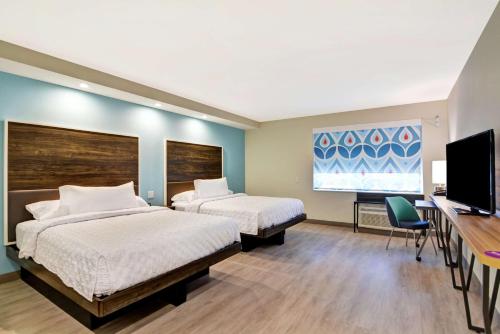巴吞鲁日Tru By Hilton Baton Rouge Citiplace的酒店客房设有两张床和一台平面电视。