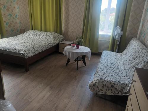 图库姆斯Dzīvoklis Tukuma centrā的一间卧室配有两张床、一张桌子和一把椅子