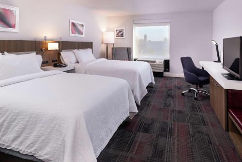 哥伦比亚Hilton Garden Inn Columbia Downtown的酒店客房设有两张床和电视。