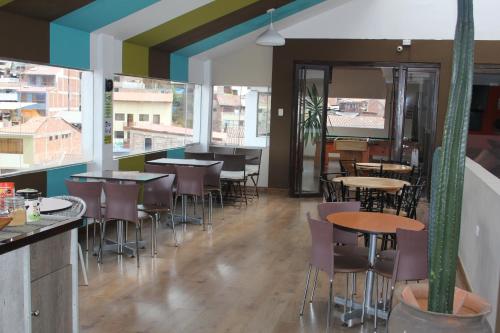 库斯科库斯科行囊旅舍的餐厅设有桌椅和窗户。
