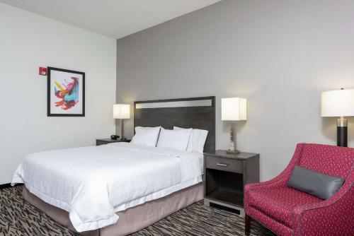 亚克朗南阿克伦汉普顿酒店的酒店客房,配有一张床和一张红色椅子