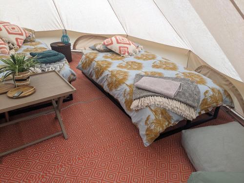 雷克瑟姆Stay Wild Retreats 'Glamping Pods and Tents'的一间设有两张床的房间和一张帐篷内的桌子