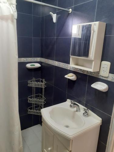 拉斯格路塔斯CABAÑAS LOS OLIVOS的蓝色瓷砖浴室设有水槽和镜子