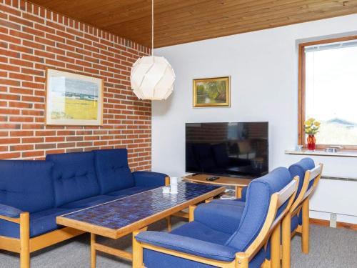 弗勒斯楚普7 person holiday home in Fr strup的客厅配有桌子和蓝色椅子