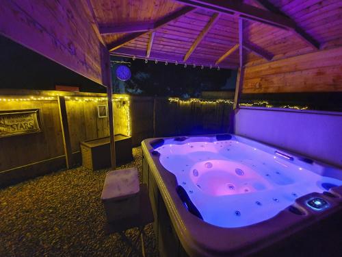 蒂斯河畔斯托克顿Thorpe Thewles Suites的紫色照明的客房内的大浴缸