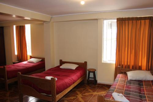 库斯科库斯科行囊旅舍的酒店客房设有两张床和窗户。