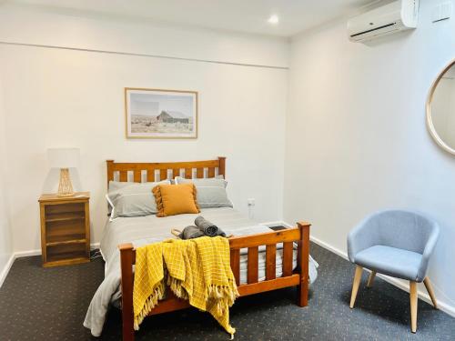 TalbingoTalbingo Lodge - Selwyn Accommodation的一间卧室,配有一张桌子上泰迪熊的床