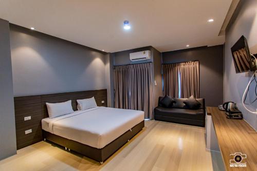 Ban KohongSP Residence Hatyai的一间卧室配有一张床和一张沙发