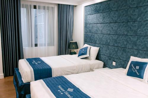 芹苴Senior Hotel的酒店客房设有两张床和窗户。