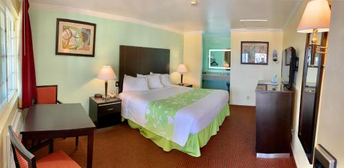 莫罗贝Morro Bay Beach Inn的酒店客房设有一张大床和一张书桌。
