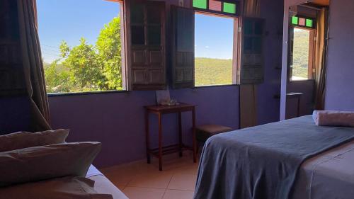 伦索伊斯Pousada do Tom的一间卧室设有两张床和一个美景窗户。