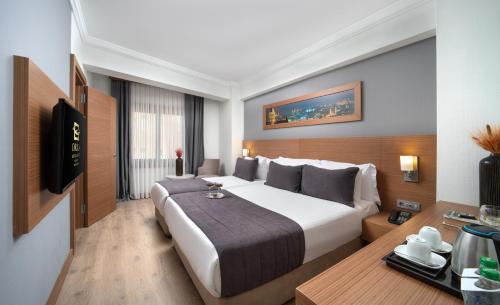 伊斯坦布尔奥卡皇家Spa酒店的酒店客房设有一张大床和一张书桌。