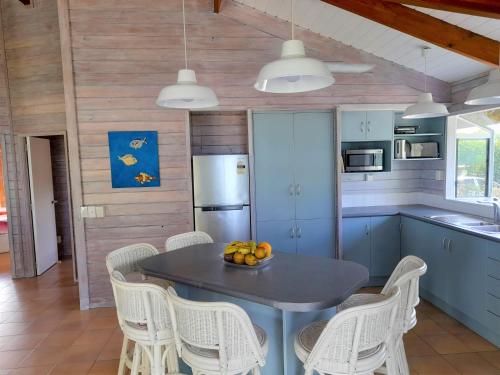 拉罗汤加沙滩别墅的厨房配有蓝色的桌子和白色的椅子