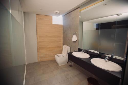 达累斯萨拉姆Giraffe Beach Hotel的一间带两个盥洗盆和卫生间的浴室