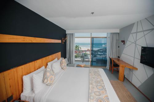 达累斯萨拉姆Giraffe Beach Hotel的一间卧室设有一张床,享有海景