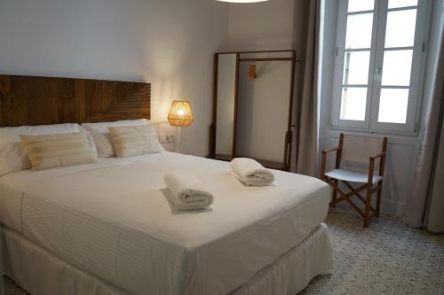 休达德亚Es Mirador Hotel的卧室配有带毛巾的大型白色床
