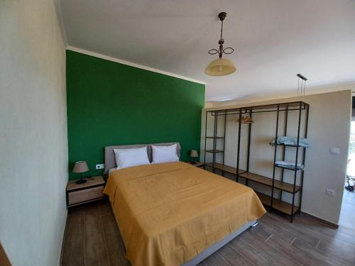萨莫色雷斯Pezoulia Cottages的一间卧室设有绿色的墙壁和一张床