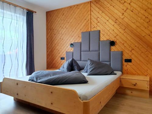 恩斯塔尔豪斯Apartment Steirawohnzimmer的木墙客房的一张床位