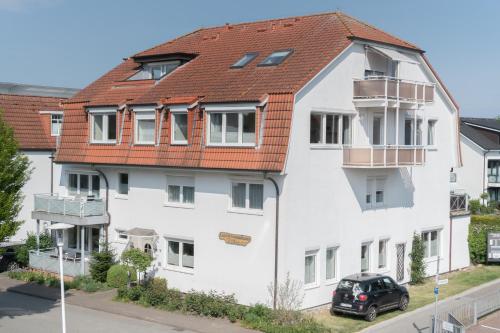 格洛米茨Appartementhaus Christel的白色的建筑,有红色的屋顶