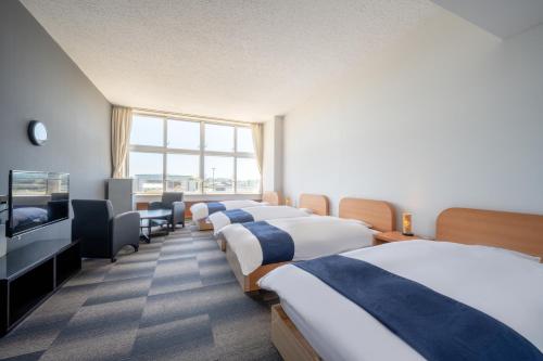 东松岛KIBOTCHA/キボッチャ的酒店客房设有四张床和平面电视。