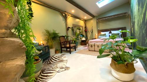 纳博讷Tropical Lodge SPA Narbonne的一间卧室,配有一张床,种满了植物