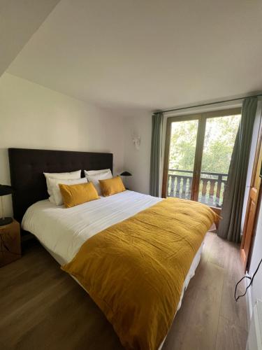 梅杰夫N5 Megève - Résidence de L'ours - appart 4 pers的一间卧室配有一张带黄色毯子的大床