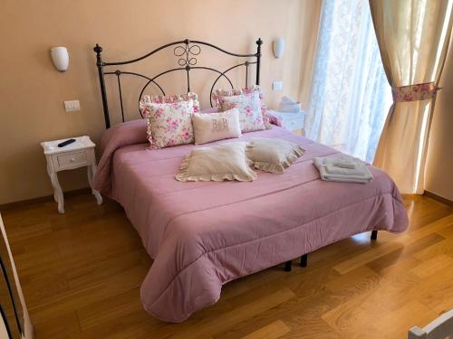 萨尔扎纳皮亚泽塔住宿加早餐旅馆的卧室配有一张大床,配有粉色床单和枕头