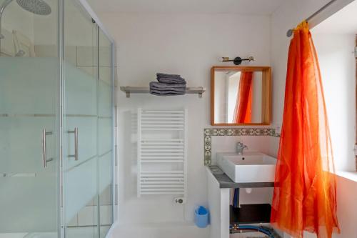 TornacMazet Tornac的浴室内配有橙色淋浴帘和水槽