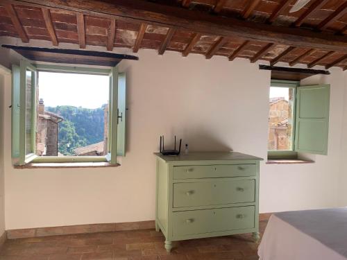LubrianoCivita Secret Lodge的一间带绿色梳妆台和2扇窗户的卧室