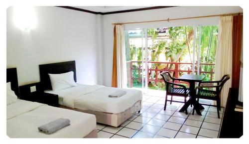 Prasat通皮克酒店的一间卧室设有两张床、一张桌子和一个窗口