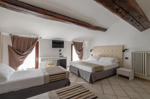 曼托瓦Hotel Mantegna Stazione的酒店客房设有两张床和电视。