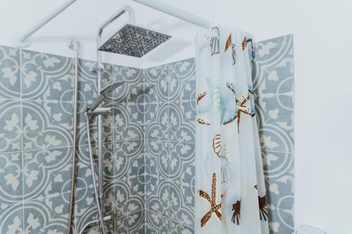 伊斯基亚Lemon Tree Rooms的浴室设有蓝色和白色瓷砖淋浴。