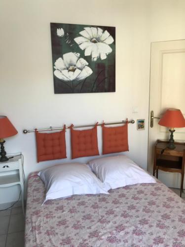 蒙彼利埃Chambre Abri Urbain的一间卧室配有一张带两盏灯的床,墙上挂着一张照片