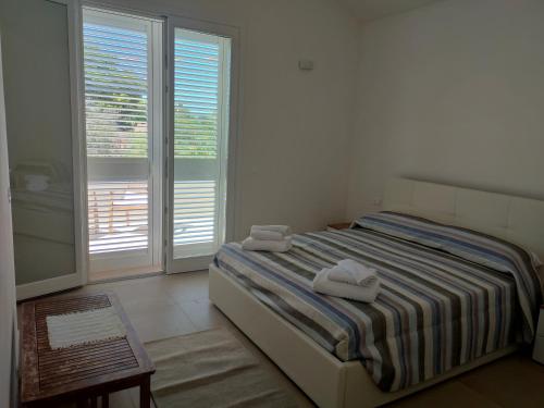 马尔萨拉La casetta della Pigna Verde的一间卧室配有一张床,上面有两条毛巾