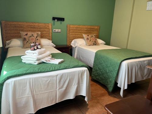厄尔埃基多HOSTAL TREVELEZ的绿墙客房内的两张床